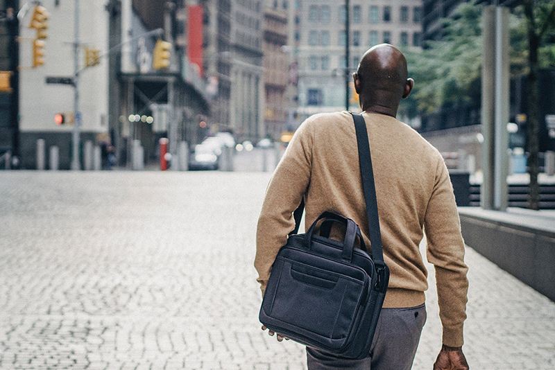 Man with a laptop bag walking in a city