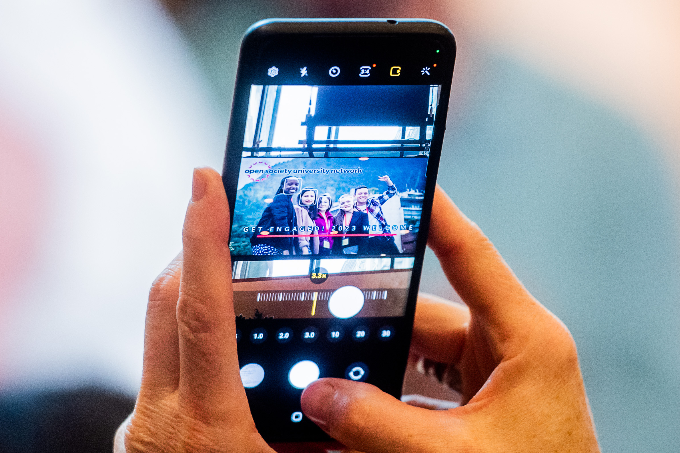 Person taking a photo with a phone of Get Engaged conference banner
