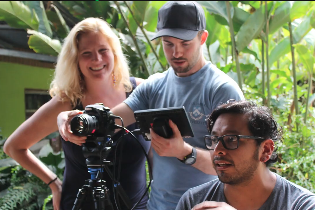 Three people working behind a camera